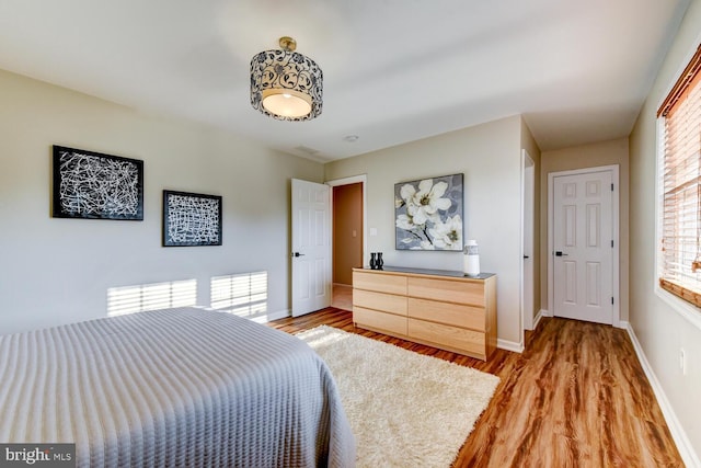 bedroom featuring light wood-style floors and baseboards