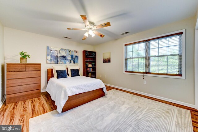bedroom with baseboards, wood finished floors, and a ceiling fan