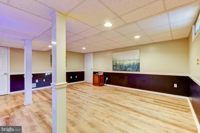 below grade area with wood finished floors, a drop ceiling, wainscoting, baseboards, and recessed lighting