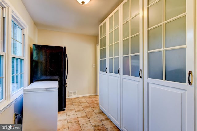 clothes washing area featuring healthy amount of natural light and baseboards