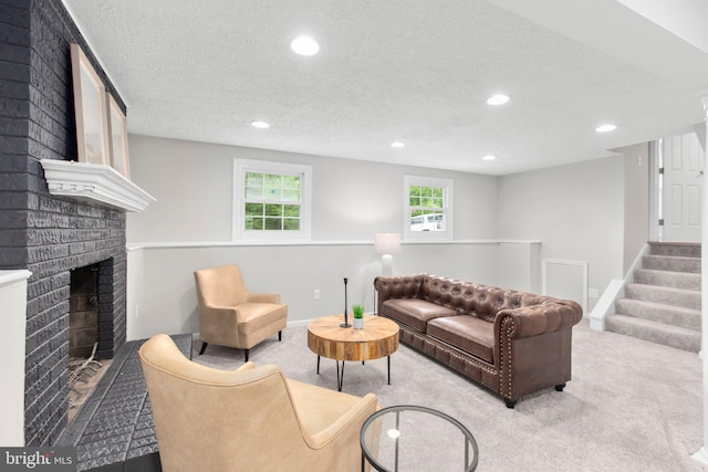 living room with a textured ceiling, a brick fireplace, stairway, carpet floors, and recessed lighting