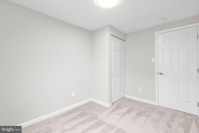 unfurnished bedroom with baseboards and carpet