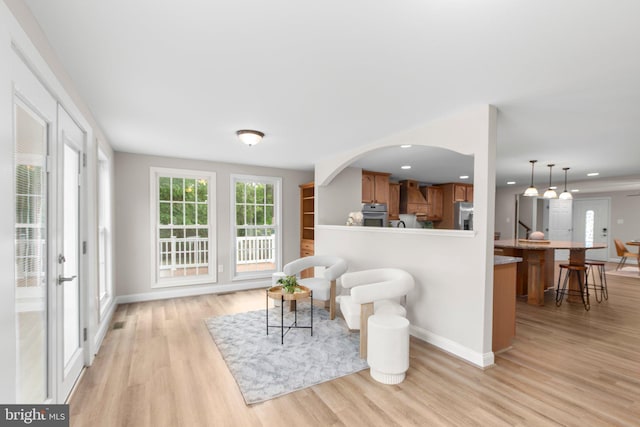 sitting room with baseboards, recessed lighting, and light wood-style flooring