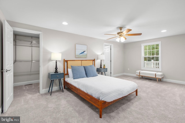bedroom with a closet, baseboards, carpet flooring, and a spacious closet