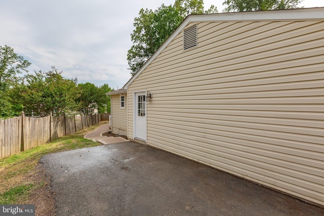 view of property exterior with fence and a patio