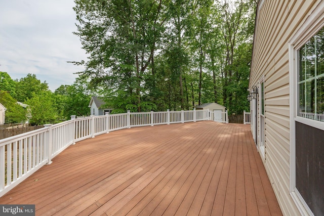wooden deck with a storage shed and an outbuilding