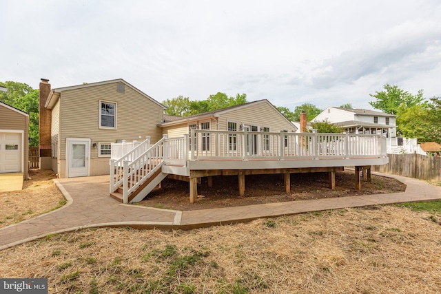 back of house with stairway, fence, and a wooden deck