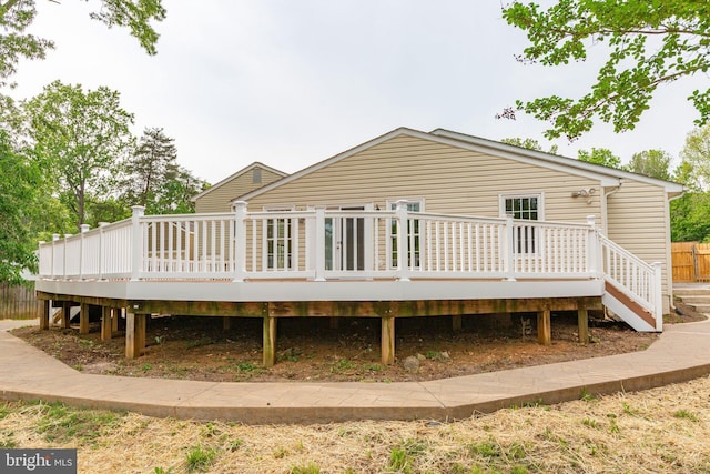 rear view of house with a wooden deck and fence