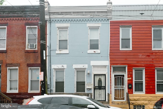 view of property featuring brick siding and cooling unit