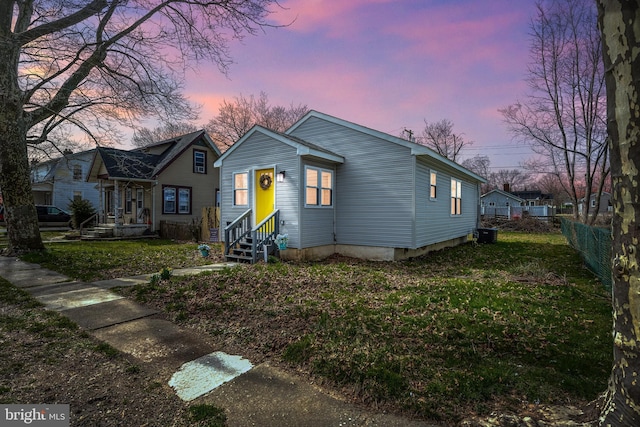bungalow-style house with entry steps, fence, and a front yard