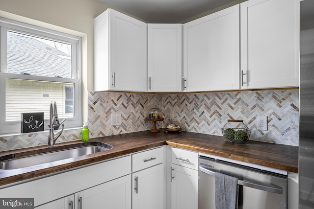 kitchen featuring a sink, wood counters, backsplash, and dishwasher