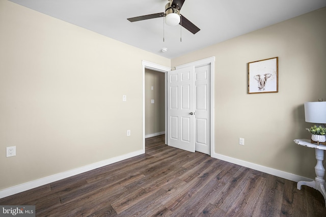 unfurnished bedroom with baseboards, a ceiling fan, and dark wood-style flooring