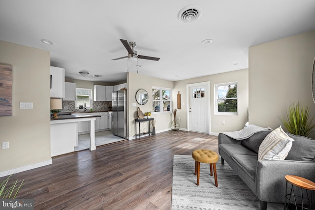 living room with a ceiling fan, baseboards, recessed lighting, wood finished floors, and visible vents