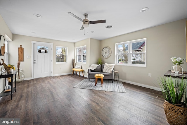 living area featuring baseboards, ceiling fan, visible vents, and wood finished floors
