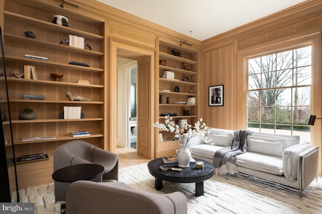 sitting room with wooden walls and built in shelves