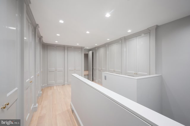 hallway featuring light wood-style floors, recessed lighting, and an upstairs landing