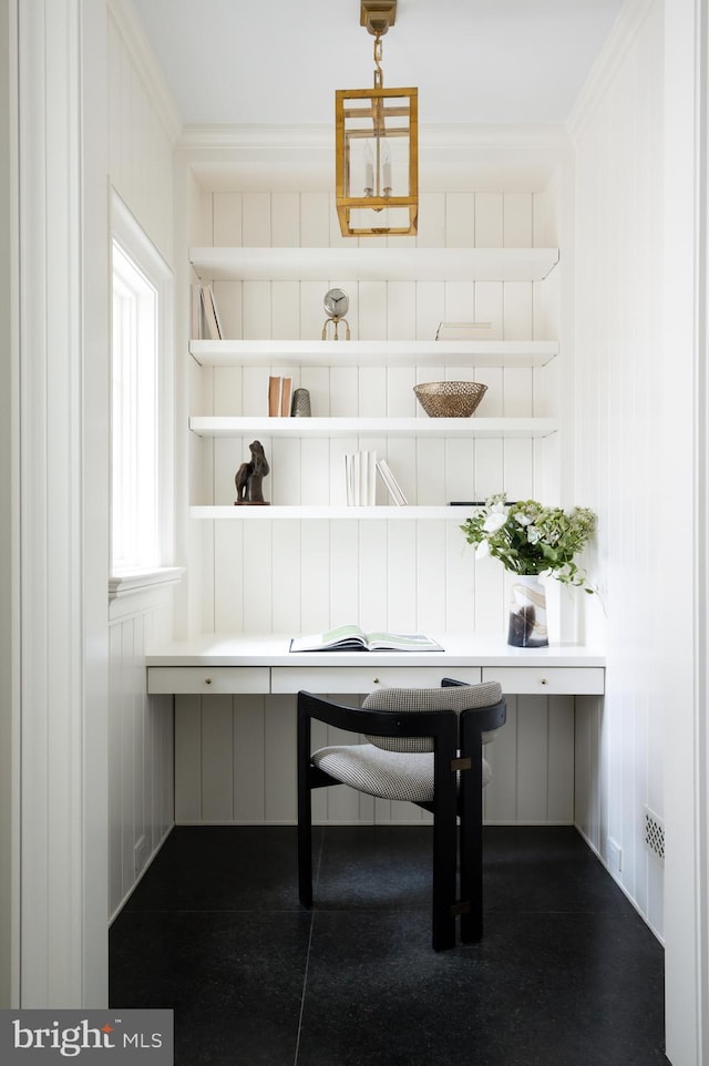 unfurnished office featuring crown molding and built in desk