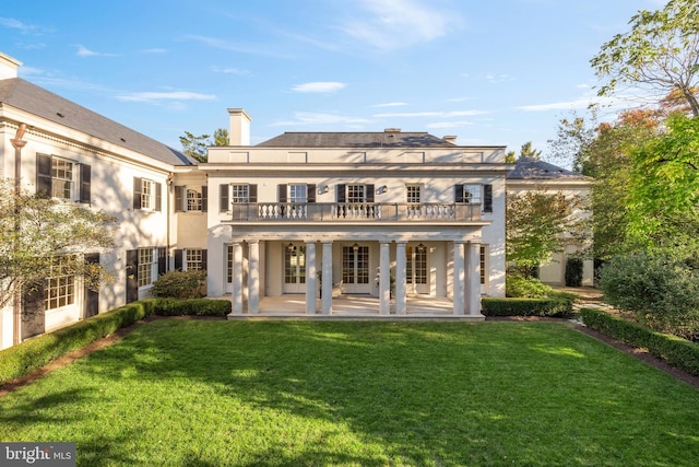 rear view of property featuring french doors, stucco siding, a yard, and a patio area