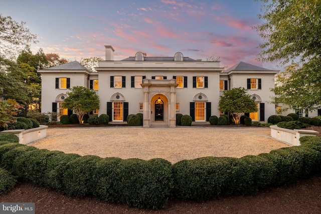view of front of property featuring stucco siding and a chimney