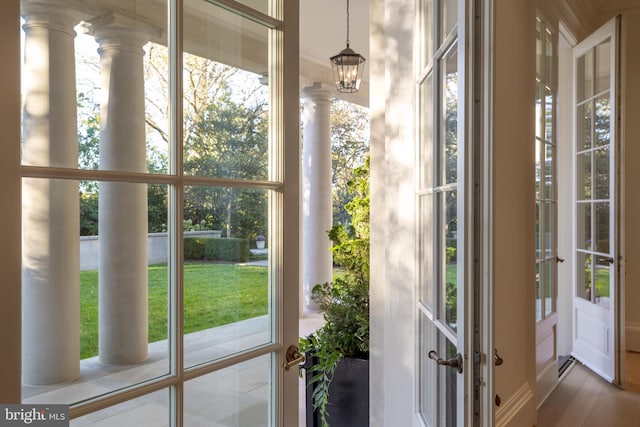 doorway with ornate columns and a chandelier