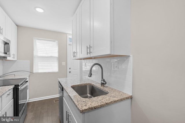 1414 N Bethel St, Baltimore, MD 21213 - kitchen with stainless steel appliances, a sink, dark wood-style flooring, decorative backsplash, and recessed lighting