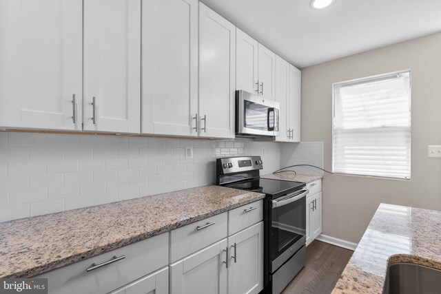 1414 N Bethel St, Baltimore, MD 21213 - kitchen with stainless steel appliances, dark wood-style flooring, backsplash, white cabinetry, and light stone countertops