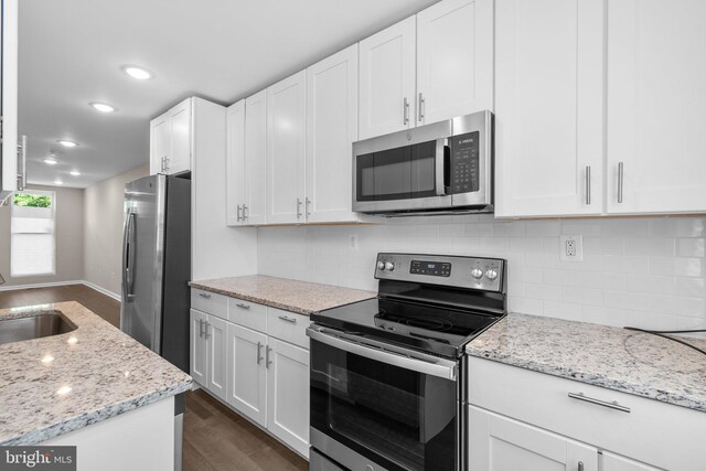 1414 N Bethel St, Baltimore, MD 21213 - kitchen featuring appliances with stainless steel finishes, dark wood finished floors, backsplash, white cabinets, and a sink