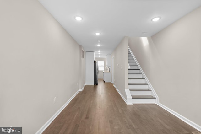 1414 N Bethel St, Baltimore, MD 21213 - corridor featuring dark wood-style floors, stairway, baseboards, recessed lighting, and a sink