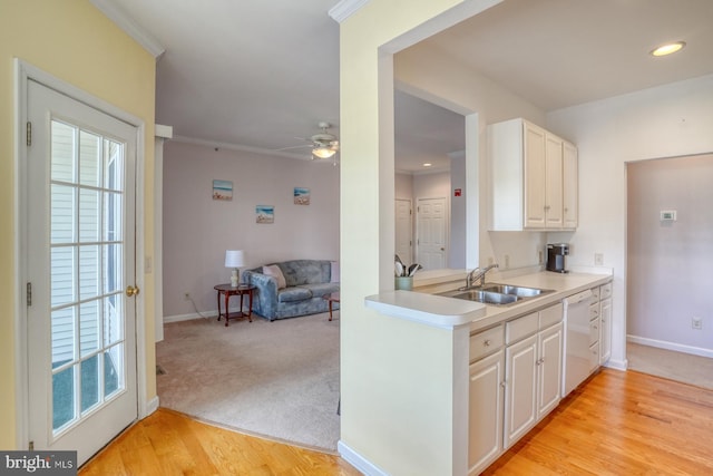 kitchen featuring ceiling fan, dishwasher, a sink, baseboards, and light countertops