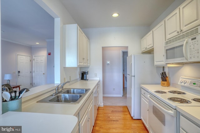 kitchen with white appliances, recessed lighting, light countertops, white cabinetry, and a sink