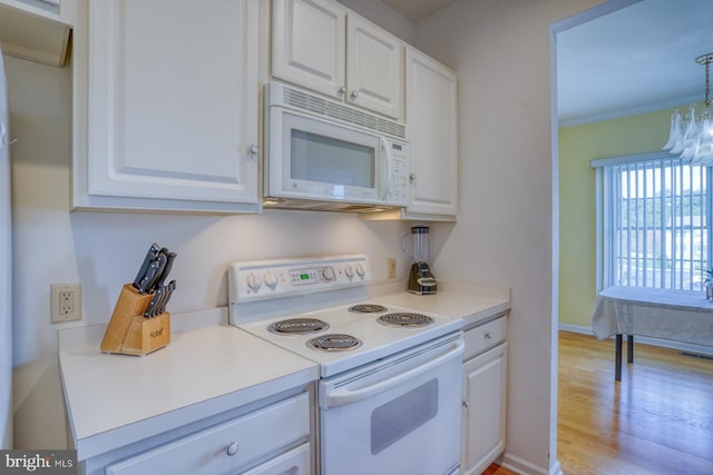 kitchen with white appliances, white cabinetry, and light wood-style floors