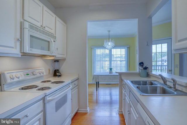 kitchen featuring a sink, light countertops, a chandelier, white appliances, and white cabinetry