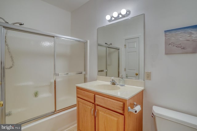 bathroom featuring vanity, toilet, and shower / bath combination with glass door