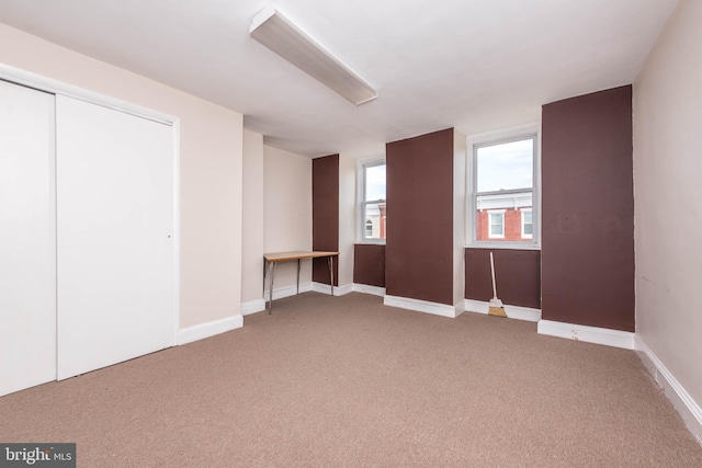 unfurnished bedroom with carpet floors, baseboards, and a closet