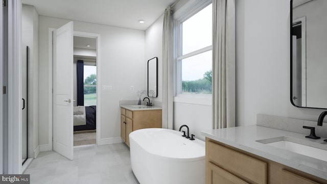 ensuite bathroom featuring a sink, ensuite bath, a freestanding bath, and two vanities