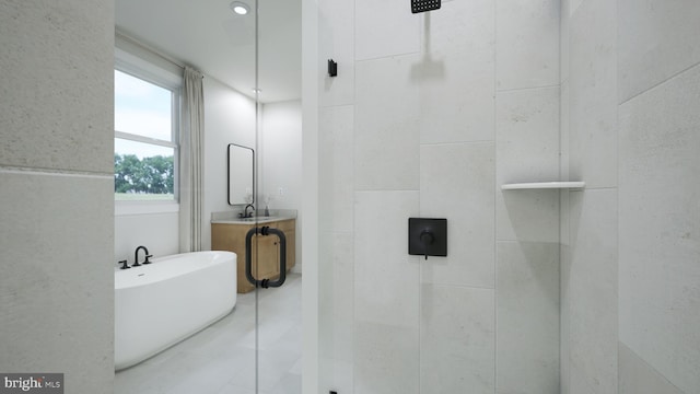 full bathroom featuring a freestanding tub, tiled shower, tile patterned floors, and vanity