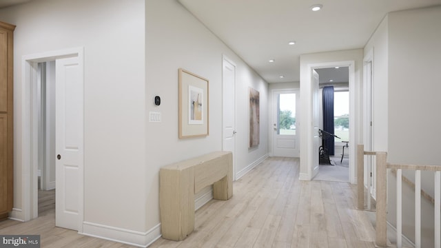 hall featuring recessed lighting, light wood finished floors, baseboards, and an upstairs landing