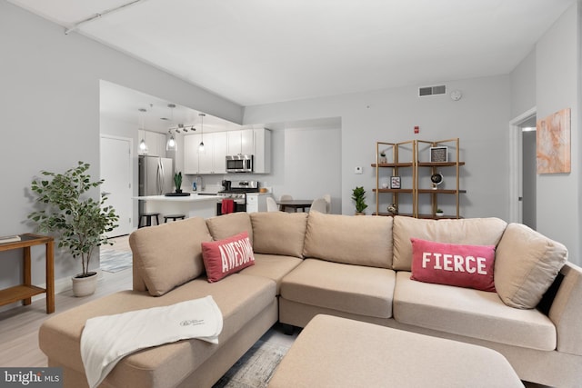 living room featuring visible vents and light wood-style flooring