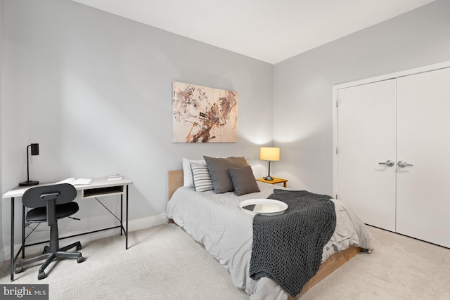 bedroom with carpet floors, baseboards, and a closet