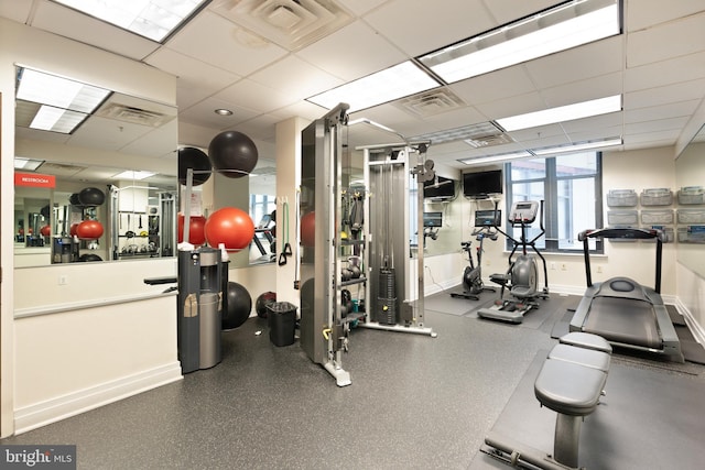 workout area featuring baseboards, visible vents, and a paneled ceiling