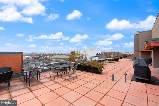 view of patio with area for grilling, a view of city, and outdoor dining space