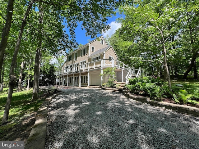 back of property with a deck and stairway