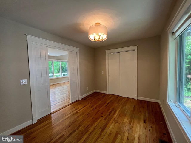 8122 Stacey Rd, Alexandria, VA 22308 - unfurnished bedroom with a closet, baseboards, hardwood / wood-style floors, and an inviting chandelier
