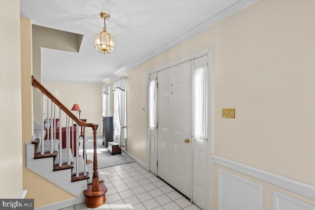 3161 Grande Oak Pl, Lancaster, PA 17601 - entryway featuring light tile patterned floors, a wainscoted wall, a chandelier, ornamental molding, and stairs