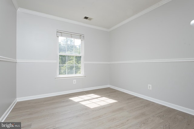 unfurnished room featuring visible vents, ornamental molding, baseboards, and light wood-style flooring