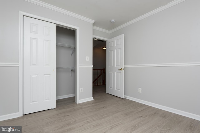 unfurnished bedroom featuring crown molding, baseboards, and wood finished floors