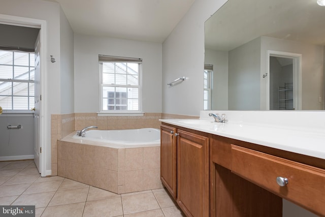 bathroom with vanity, a bath, baseboards, and tile patterned floors
