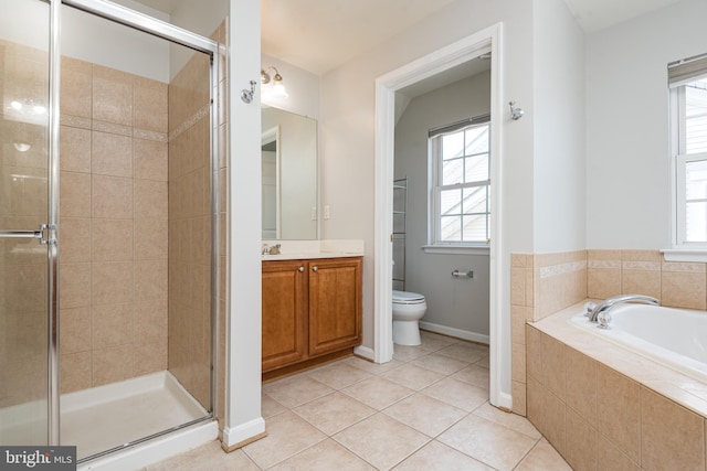 bathroom featuring a stall shower, vanity, baseboards, tile patterned floors, and toilet