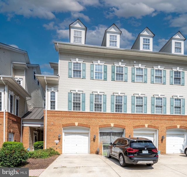view of front of property with brick siding, driveway, and a garage