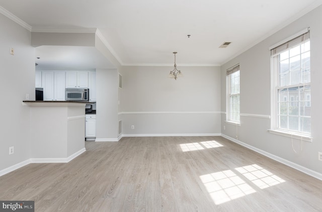 unfurnished living room featuring crown molding, baseboards, visible vents, and light wood finished floors